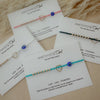 Amethyst & Owl jewelry bracelets on display with cards explaining their meanings.