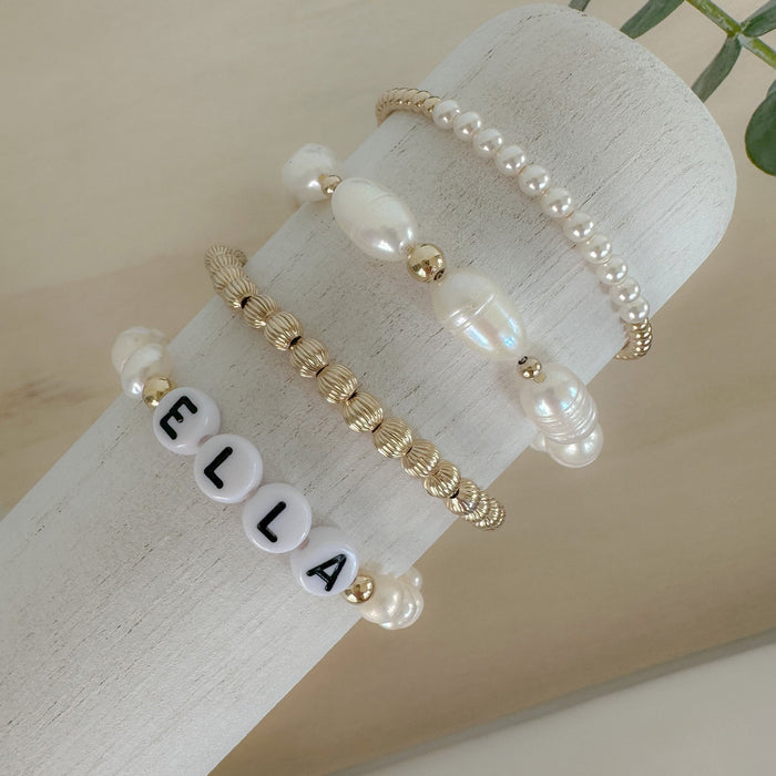 Personalized freshwater pearl bracelet with custom name, initials, or numbers. Timeless pearls + personal touch make it a meaningful gift.