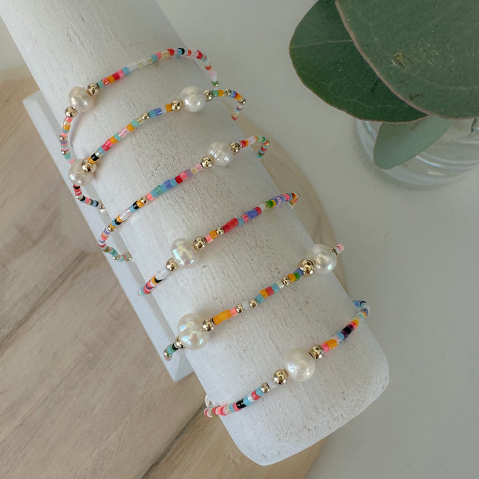 Add vibrant summer vibes to your stack with Rainbow Fun Seed Bead Bracelets featuring delicate freshwater pearls.