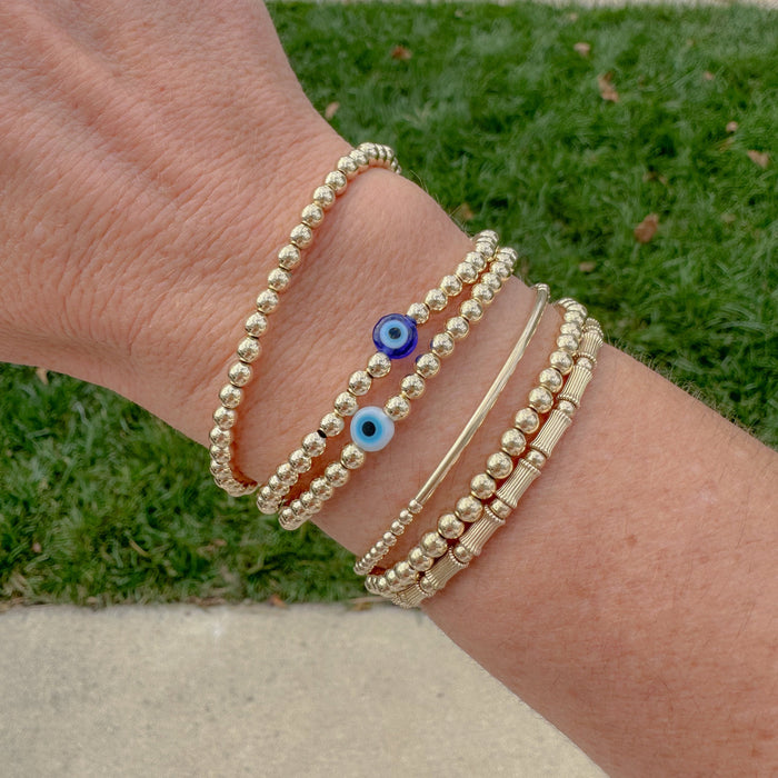 Evil Eye Bracelet – available in classic blue or white. Stackable gold-filled bracelet believed to protect against negative energy and bad luck.